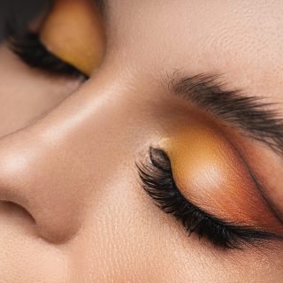 Closeup of female eyes with a colorful eyeshadow and eyebrow lamination